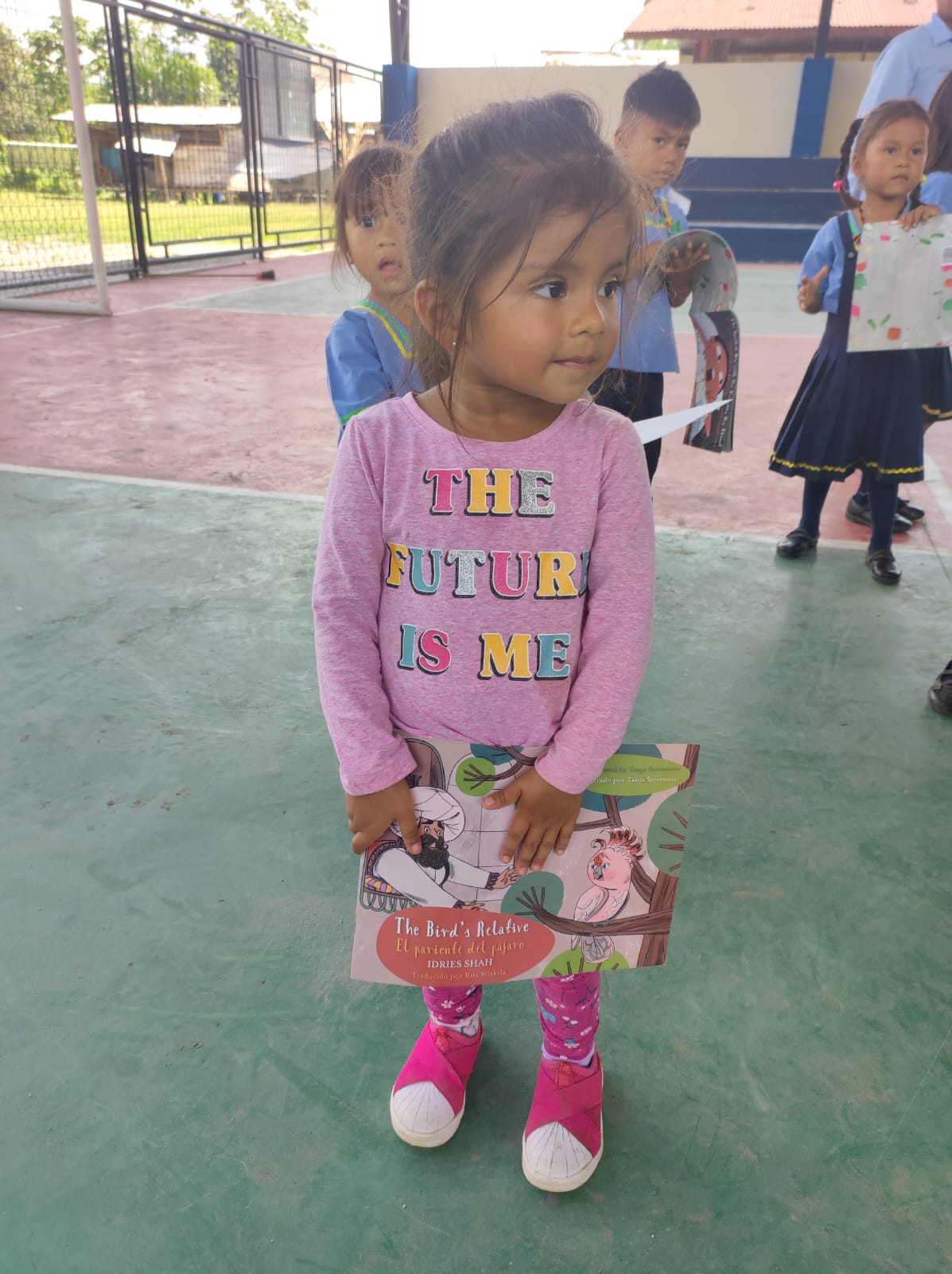 A young girl holding a Hoopoe book